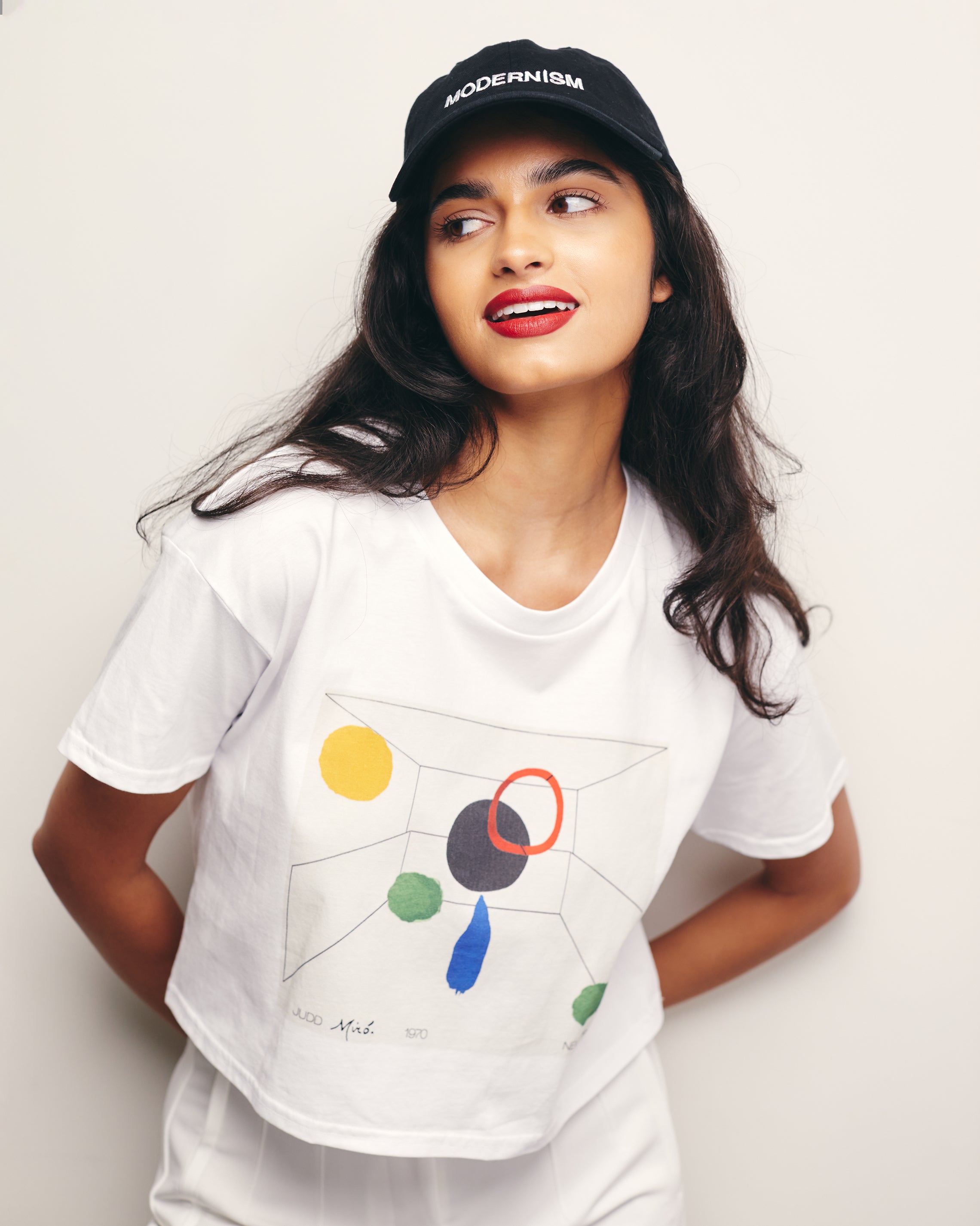 Mira Bhat wears White Cropped Short Sleeve 100% Cotton Tee with graphic print of an imaginary Exquisite Corspe collaboration between Donald Judd and Joan Miro. 