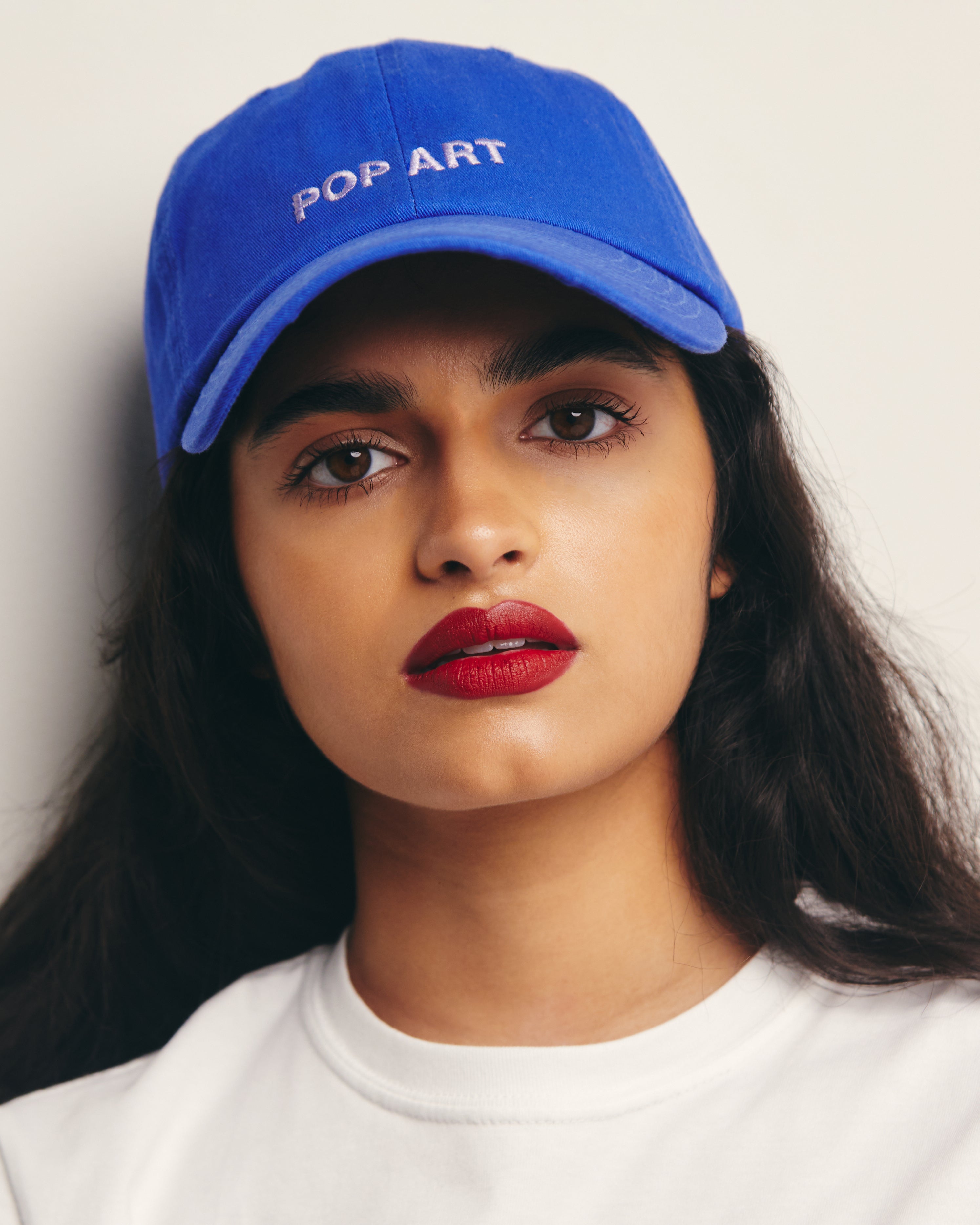 Mira Bhat wears 100% Cotton Royal Blue Dad Hat with Lavender Embroidery Pop Art Movement Text by Outsider Supply
