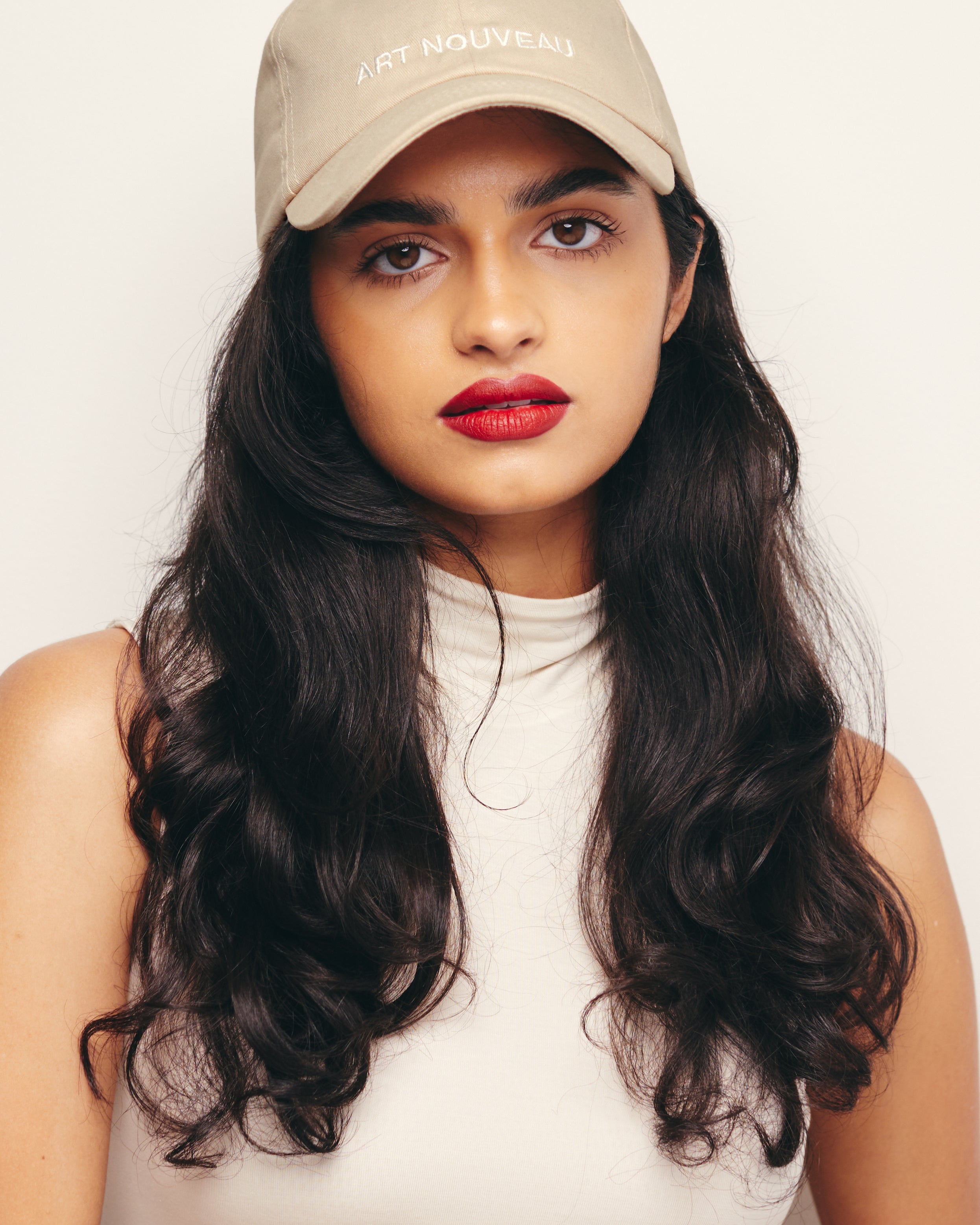 Mira Bhat wears Khaki Baseball Cap / Dad Hat with Art Nouveau Art Movement Text Embroidery on Front. 100% Cotton.