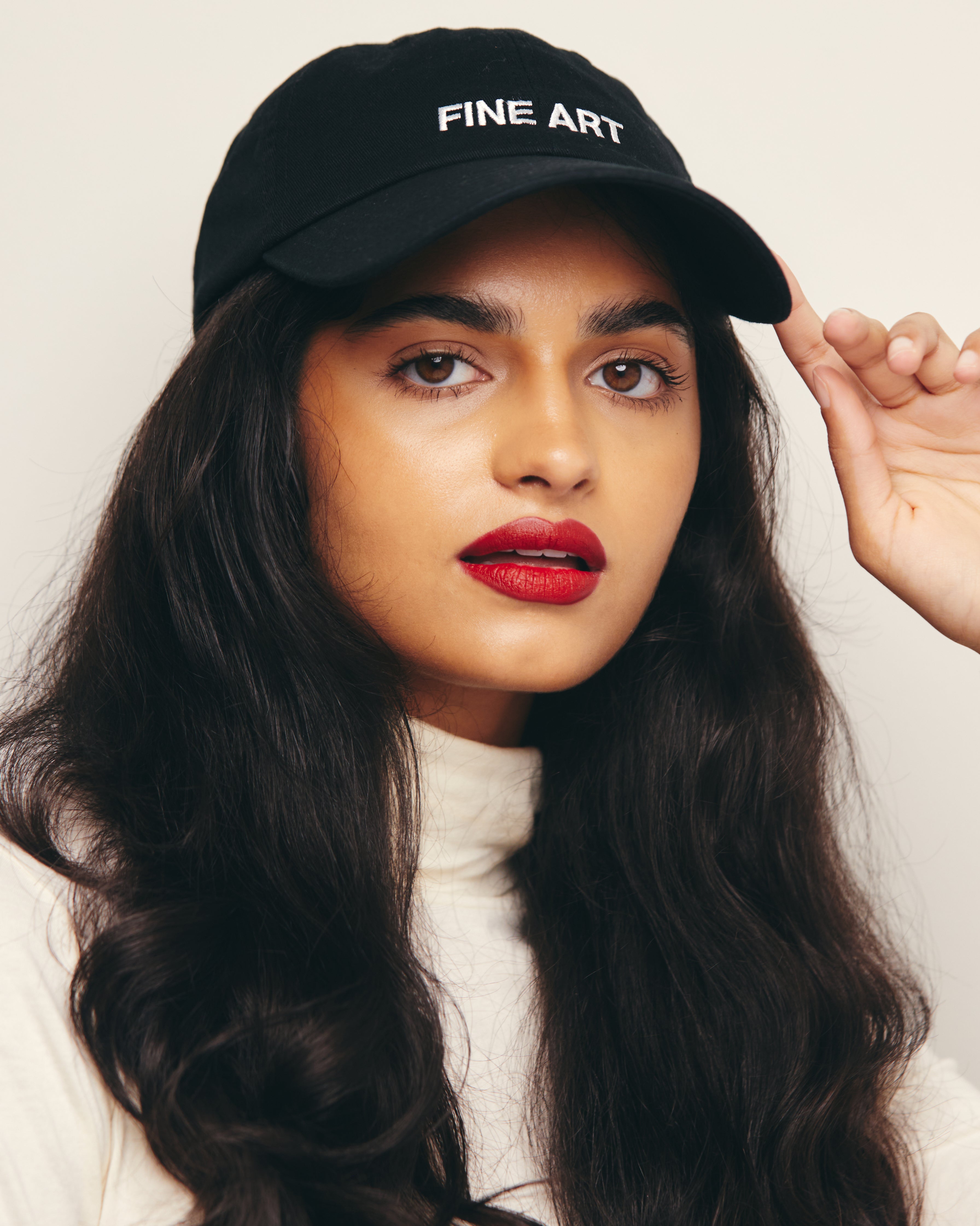 Mira Bhat wears Black Baseball Cap / Dad Hat with Fine Art Movement Text Embroidery on Front. 100% Cotton.