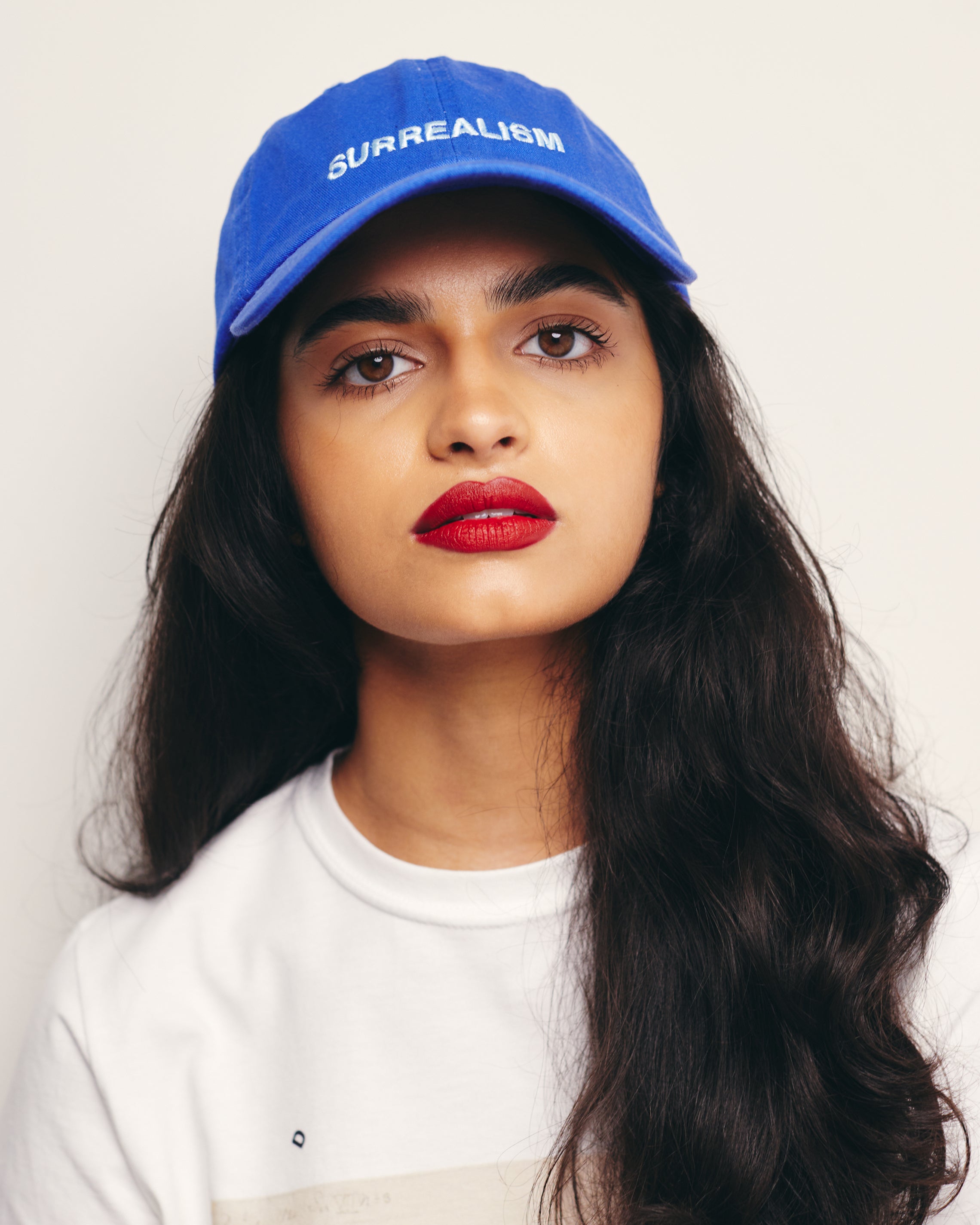Mira Bhat Wears Royal Blue Dad Hat With Surrealism Embroidery Art Movement Text