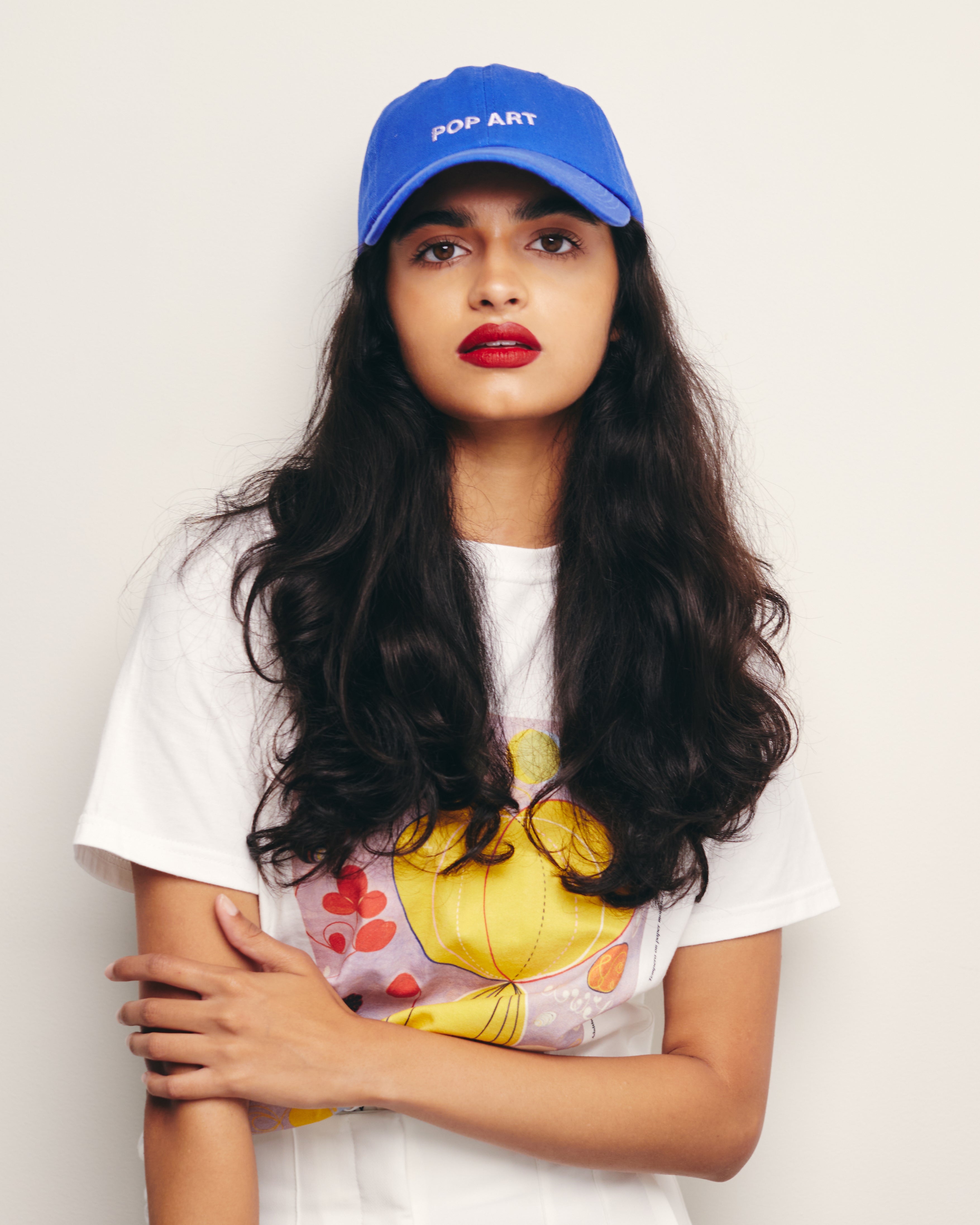 Mira Bhat Wears Royal Blue Baseball Cap / Dad Hat and 100% Organic Cotton Tee in White with Hilma af Klint Graphic Print Abstract Expressionism Art Movement Ten Largest Series Paintings
