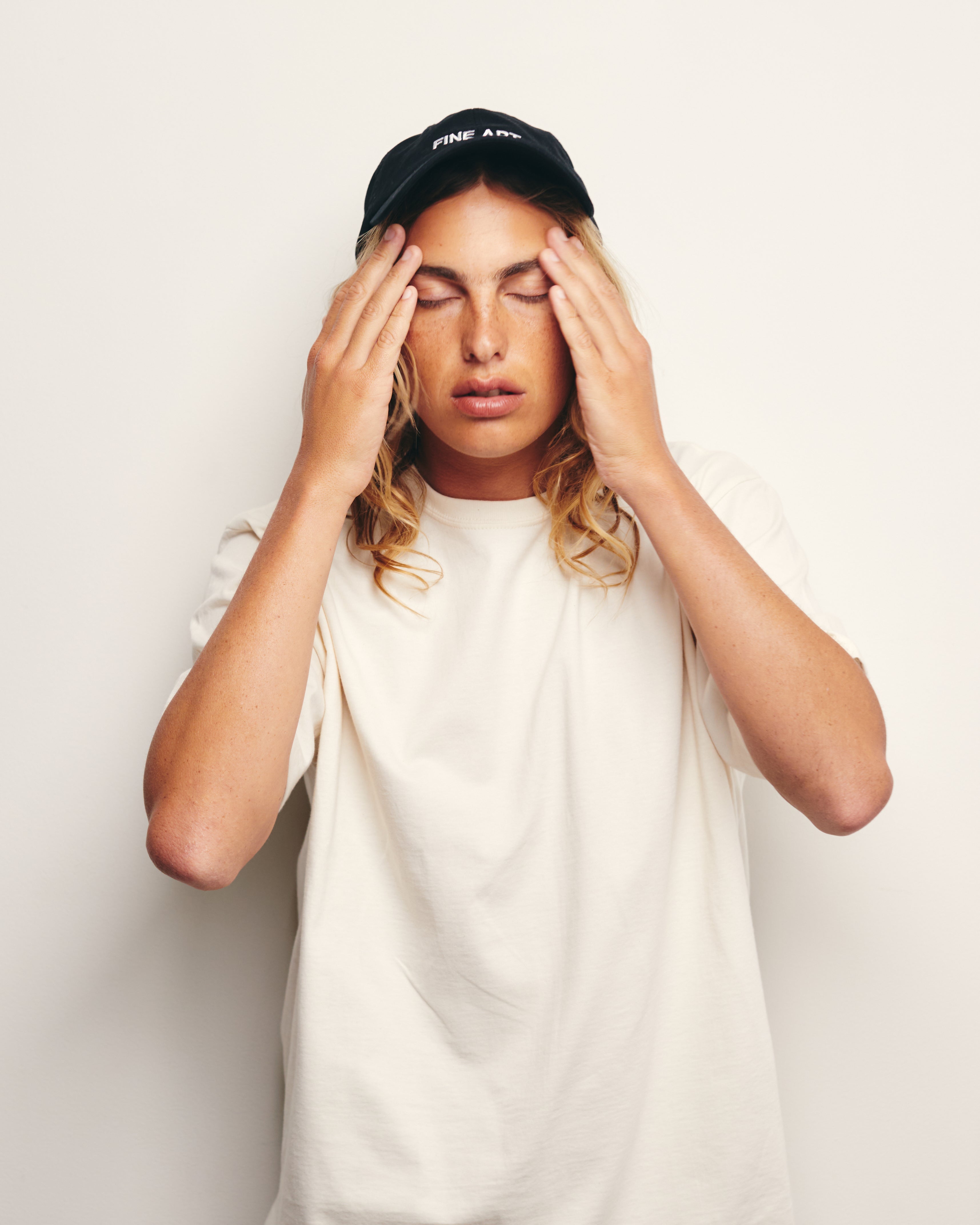 Lucas Ucedo wears Classic Cream / Off White / Ceramic Heavyweight 100% Organic Cotton Tee and Black Fine Art Baseball Cap / Dad Hat.