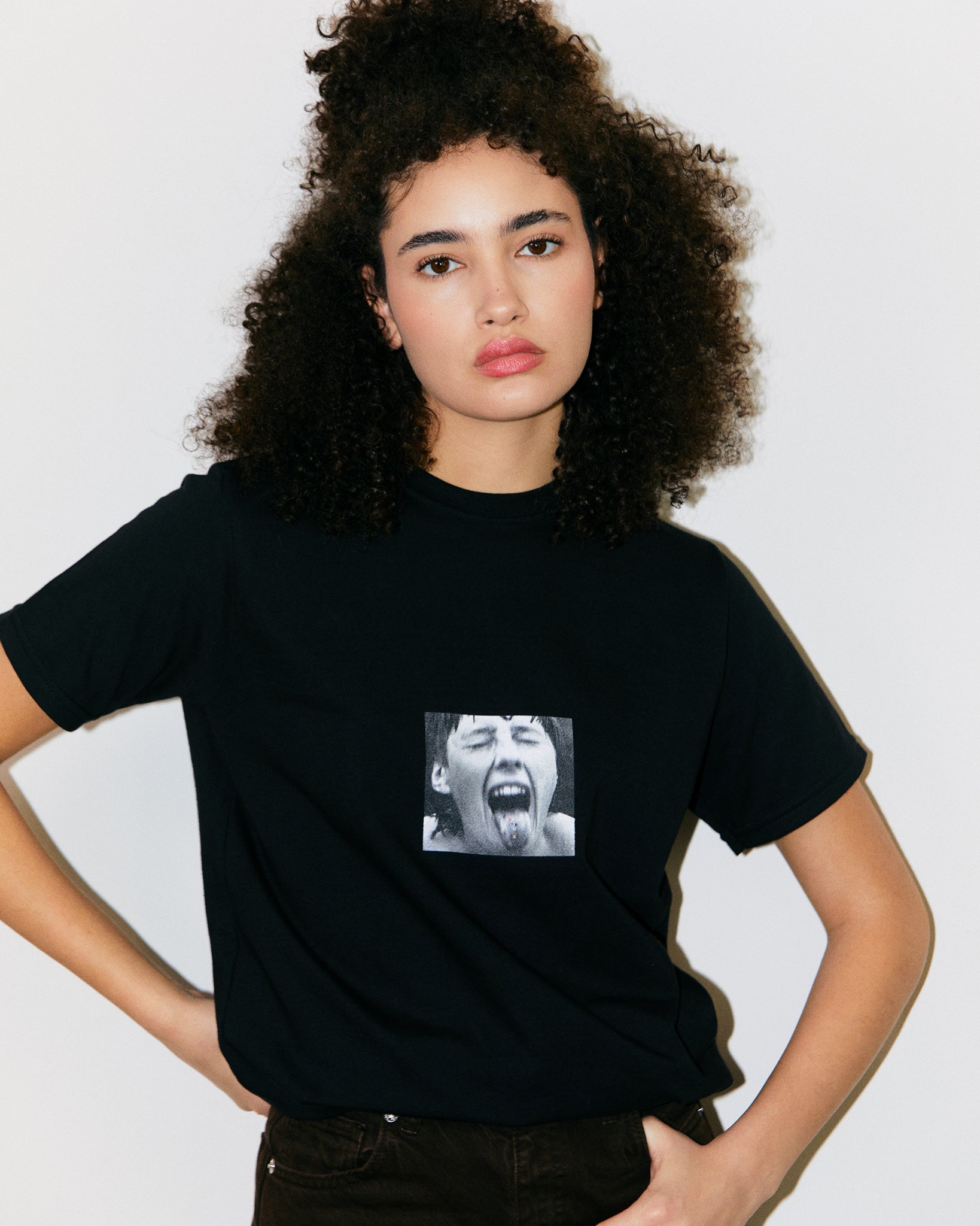 Teo Marcella Wears 100% Cotton Black Tee with Bauhaus Girl Student with Tongue Out and Bauhaus Graphic Text.